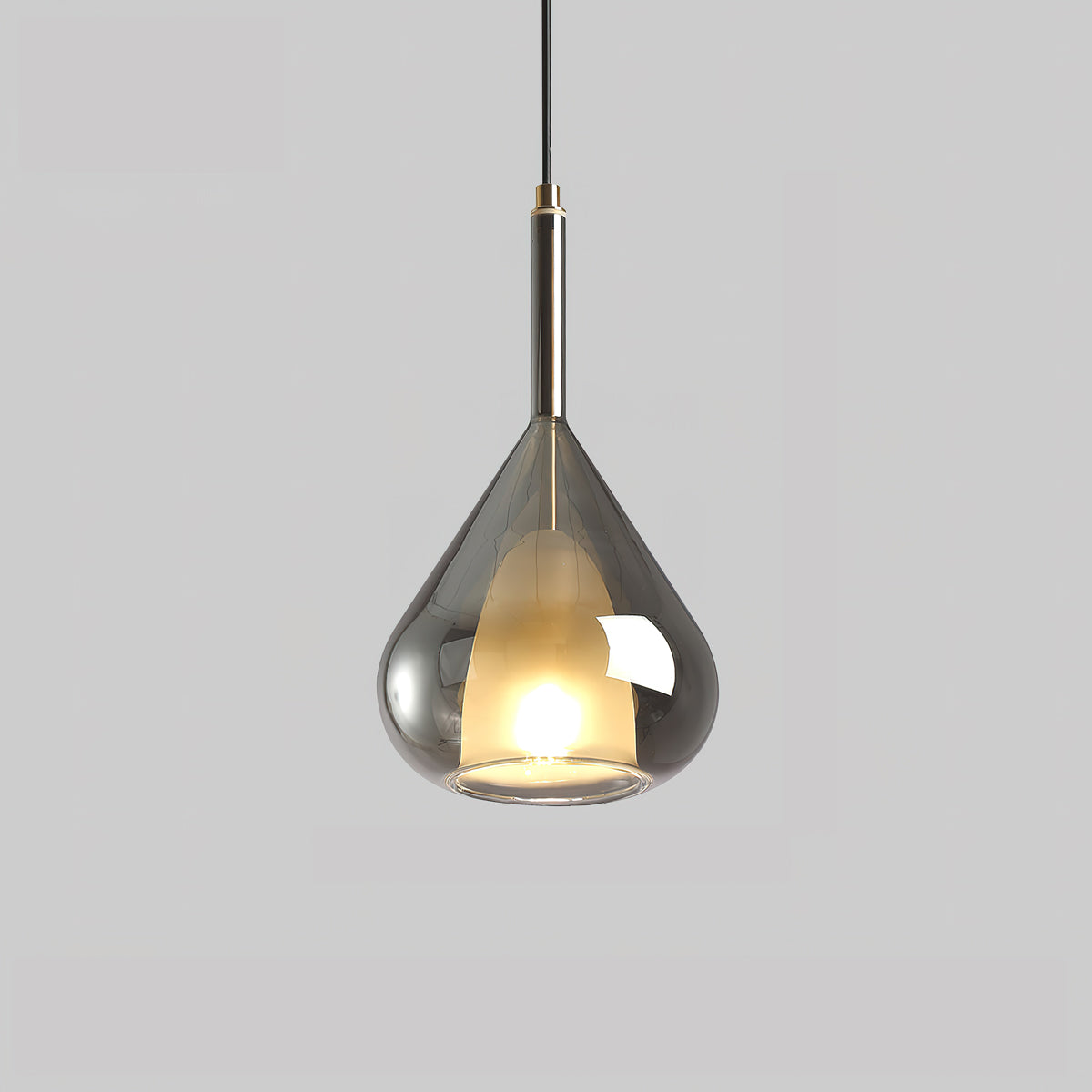 Smoke grey glass teardrop pendant from Clérachic on a pale grey backdrop, with a frosted inner shade lit warm and a dark metal stem.
