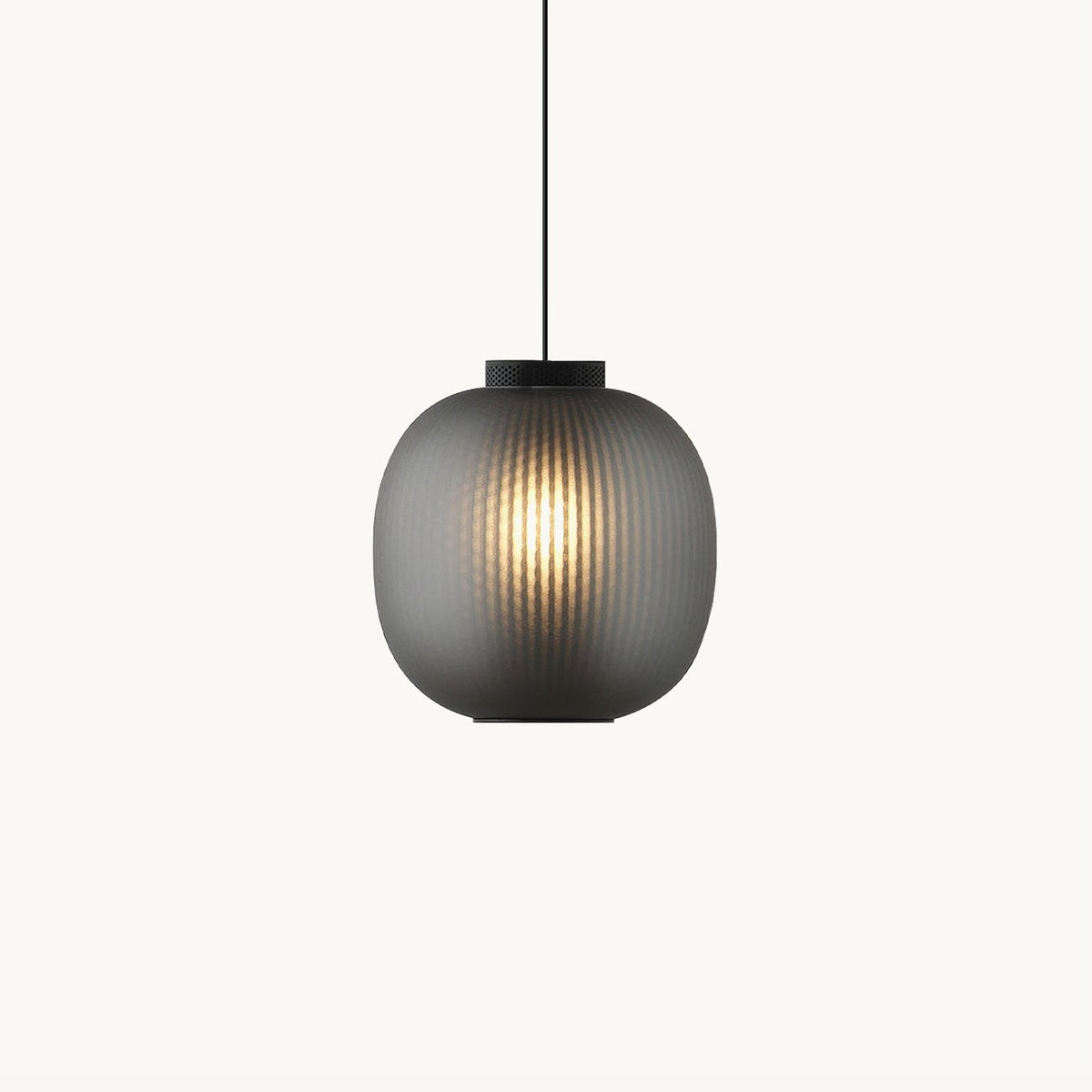 Clérachic ribbed glass pendant in smoke grey on a plain white backdrop, glowing warm through the shade with a black cap above.