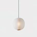 Single matte white Clérachic pendant on a pale backdrop, its ribbed glass softly glowing above a small brass-toned ring.