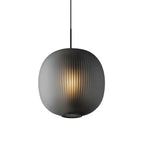 Front view of a smoke-grey Clérachic ribbed glass pendant, lit warmly, with fine vertical ribbing and a mesh ring at the base.