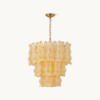 Three tiers of wavy, ribbed yellow glass panels on a short brass chain, this Clérachic pendant on a plain off-white backdrop.