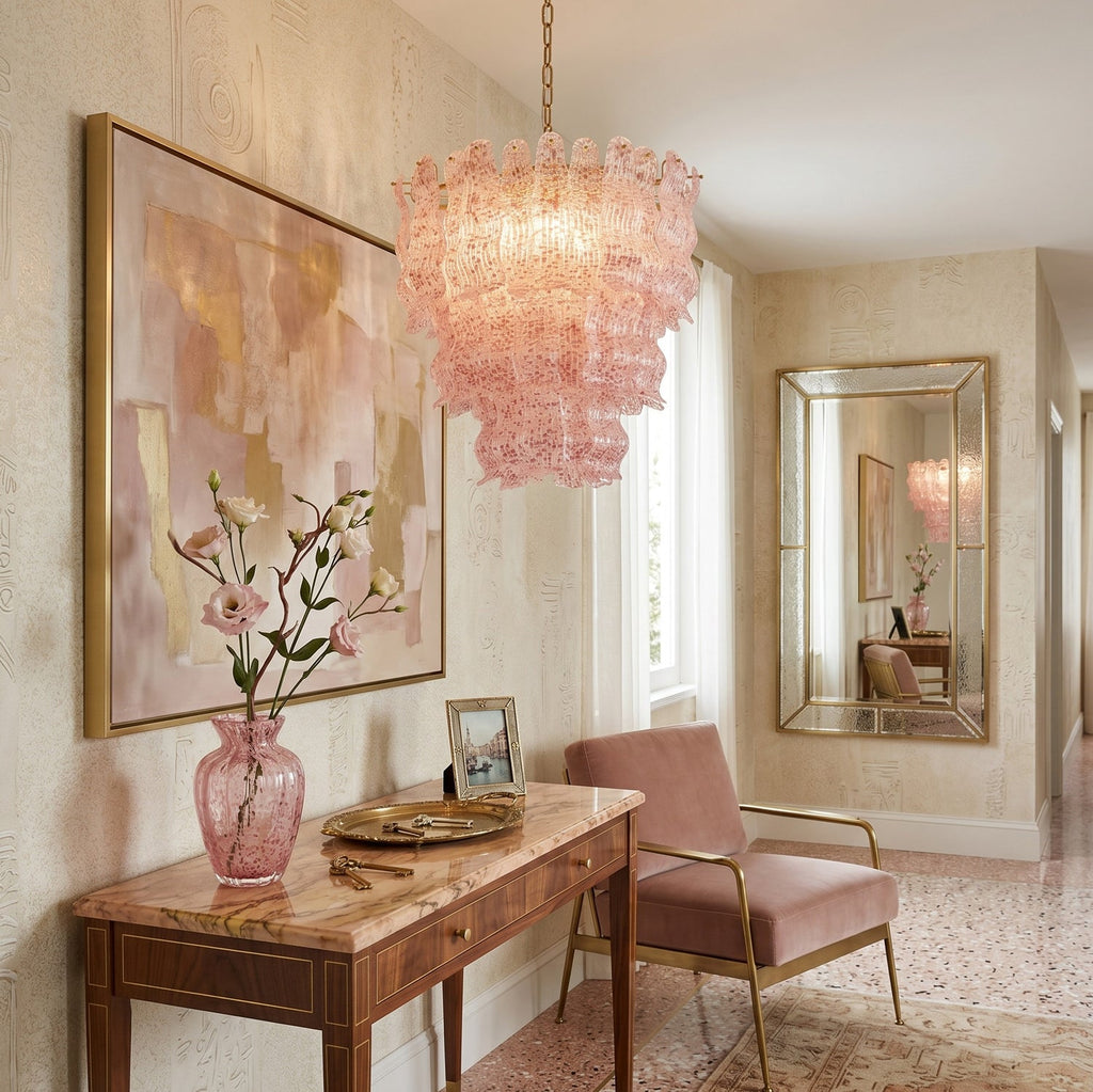 Pink glass Clérachic pendant in an entrance hall, above a wooden console with a pink vase and a pastel abstract painting.