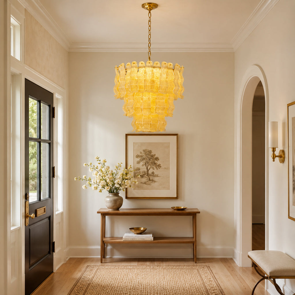 Yellow glass Clérachic pendant in a bright hallway with a dark front door, a wooden console and an arched passage.