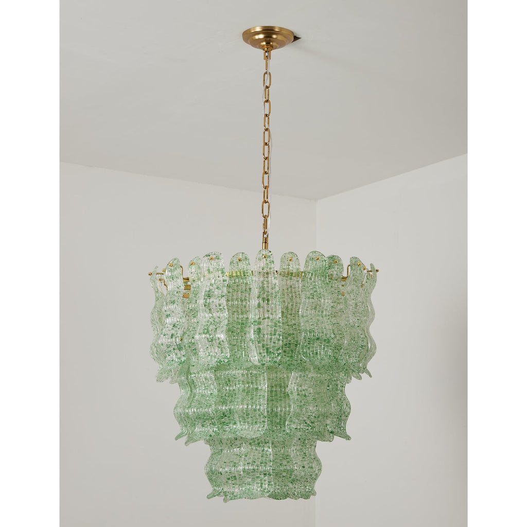 Green Clérachic pendant switched off, its pale green speckled glass tiers hung on a brass chain in a white room.