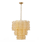 Yellow Clérachic pendant on white, the ribbed amber glass panels in three tiers beneath a brass chain.