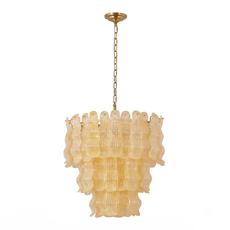 Yellow Clérachic pendant on white, the ribbed amber glass panels in three tiers beneath a brass chain.