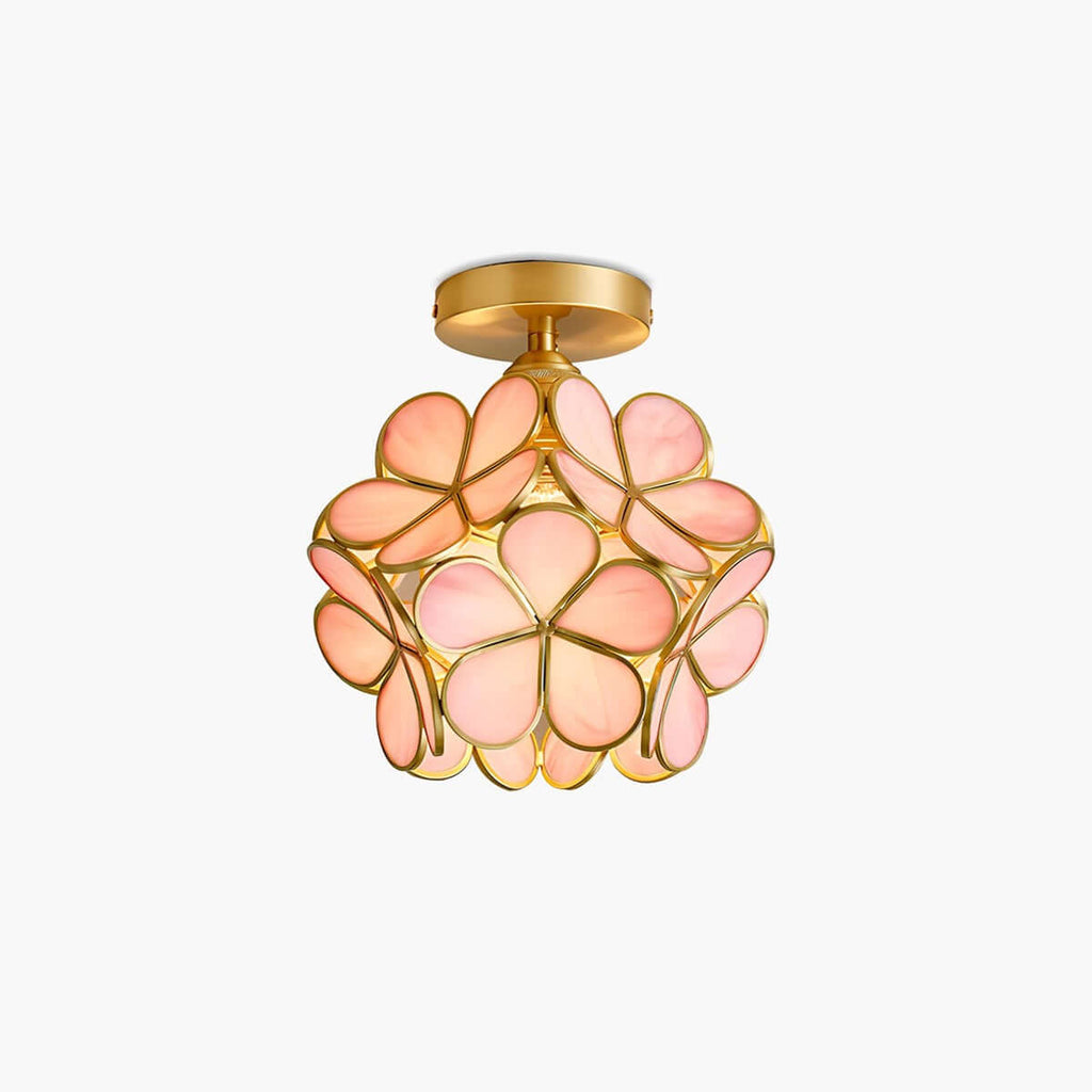 Small ceiling light of pink glass petals in a brass frame, shaped like a flower ball, on a plain white backdrop, from Clérachic.