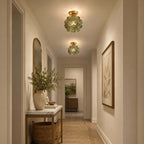 Two blue-green petal Clérachic ceiling lights along a narrow hall with a marble-topped console and a woven basket.