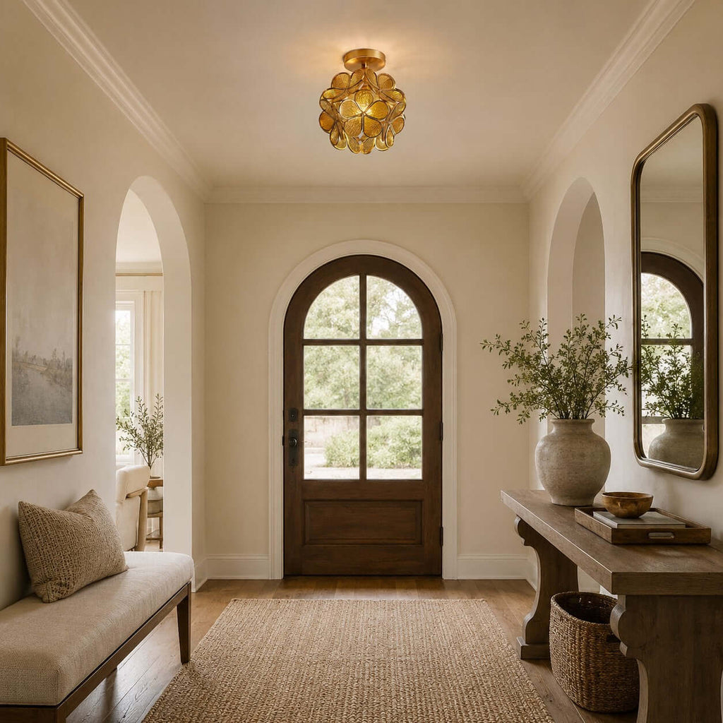 Clérachic ceiling light of clear glass petals in an entrance with an arched wooden door, a bench and a woven basket.