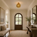 Clérachic ceiling light of clear glass petals in an entrance with an arched wooden door, a bench and a woven basket.
