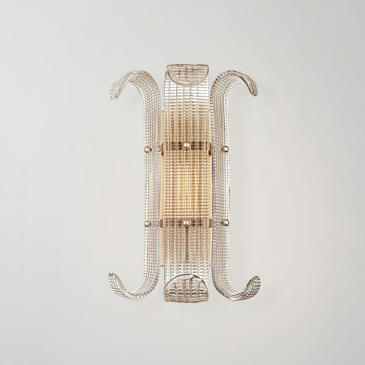 Straight-on view of this Clérachic wall light, a narrow ribbed glass shade with curled arms, lit warm against a soft grey wall.