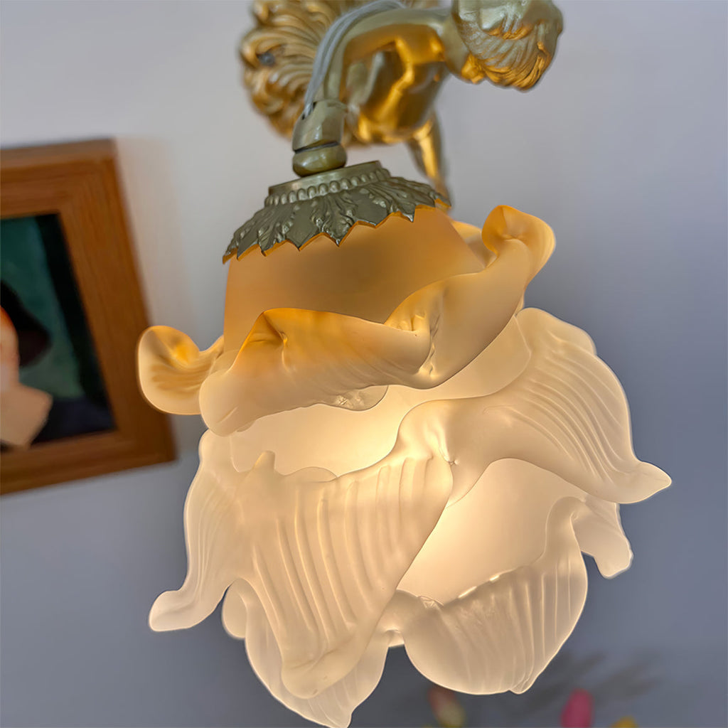 Close-up of the Clérachic glass rose wall sconce shade, the ribbed glass petals turning amber at the top and milky towards the tips.