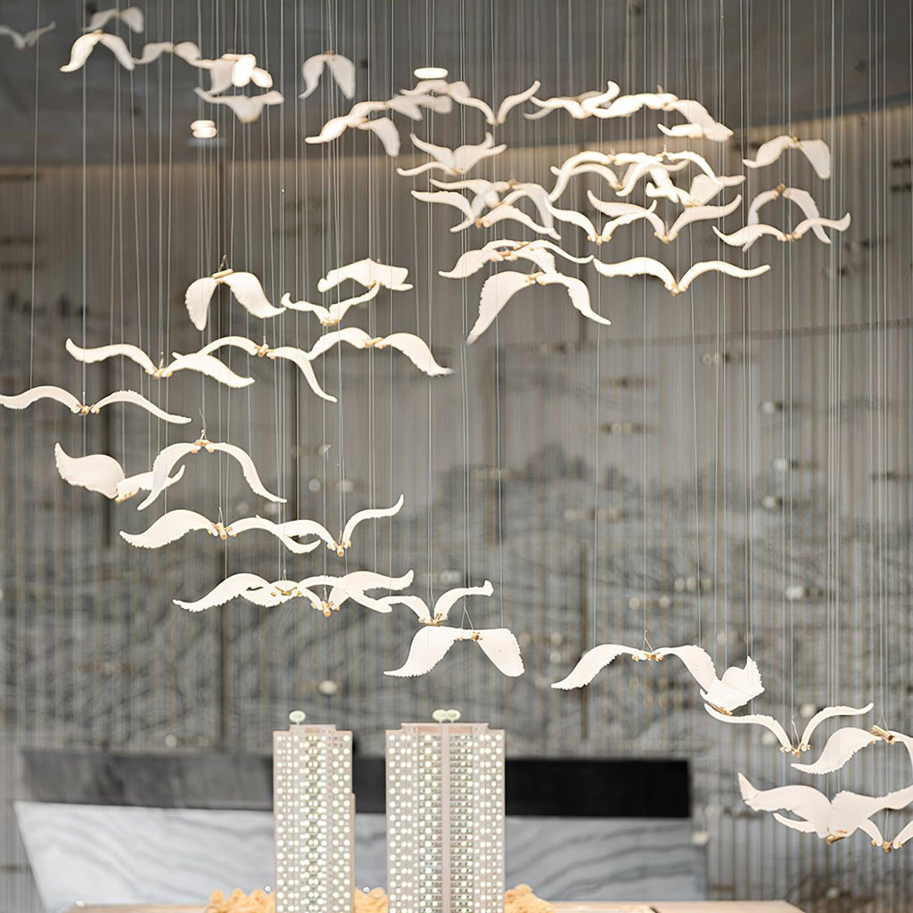 A flock of Clérachic glass seagulls fills the space above a reception desk, with two tall architectural models below.