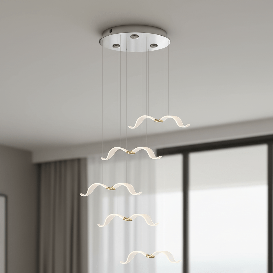 In a grey room with floor-length windows, this Clérachic seagull chandelier hangs five glowing gulls from a chrome canopy.
