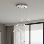 In a grey room with floor-length windows, this Clérachic seagull chandelier hangs five glowing gulls from a chrome canopy.