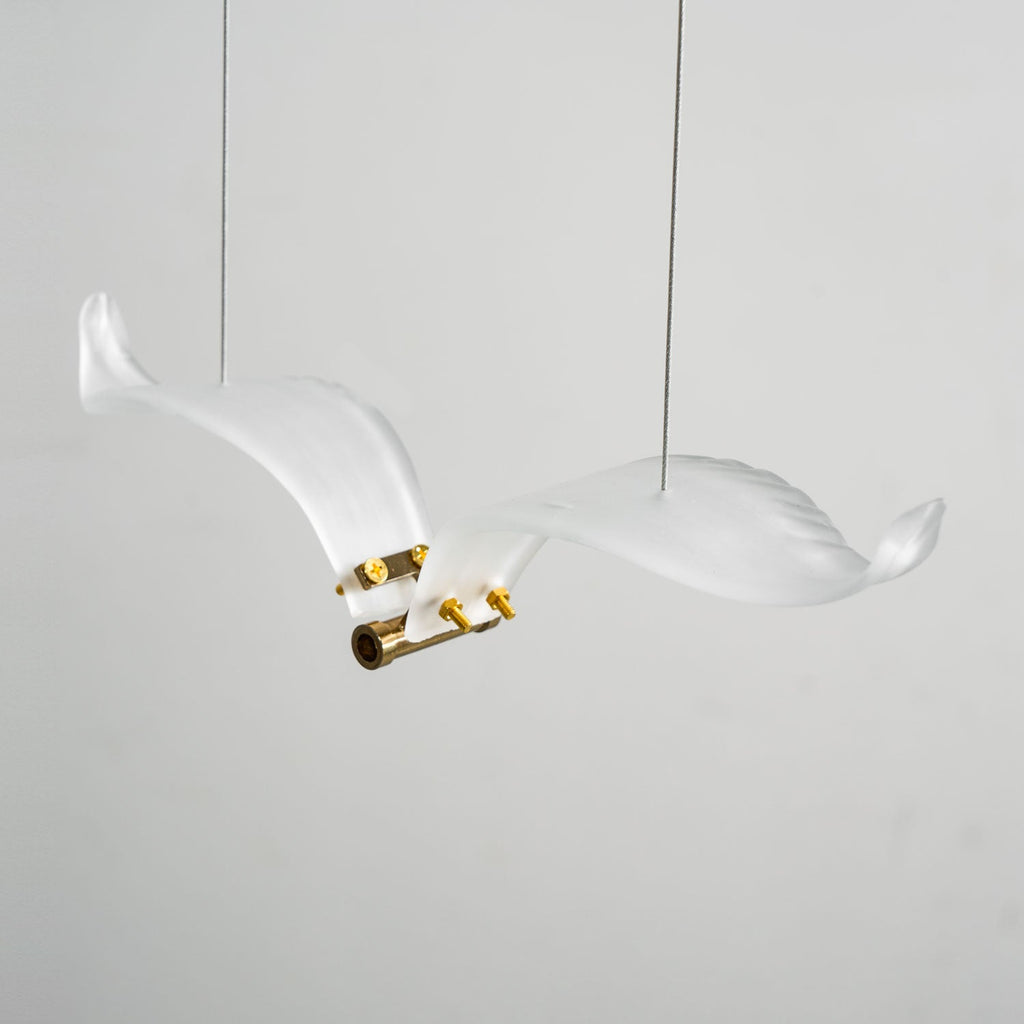 Close view of one frosted glass seagull on this Clérachic chandelier, with its brass body, screws and two thin cables.