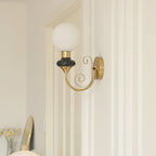 Clérachic wall light with a black collar and white globe beside a door frame, a small vase of daisies on a shelf below.