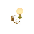 Clérachic wall light with a green collar and lit globe in profile, gold backplate on the left, on a plain white background.