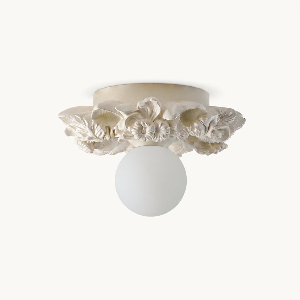 Clérachic flush-mount ceiling light in ivory white, a frosted glass sphere under a ring of carved resin petals, on a plain white backdrop.