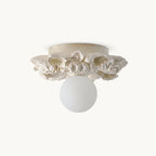Clérachic flush-mount ceiling light in ivory white, a frosted glass sphere under a ring of carved resin petals, on a plain white backdrop.