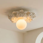 Close angle on the carved resin petals around the Clérachic light, with the frosted glass sphere glowing warm beneath them.