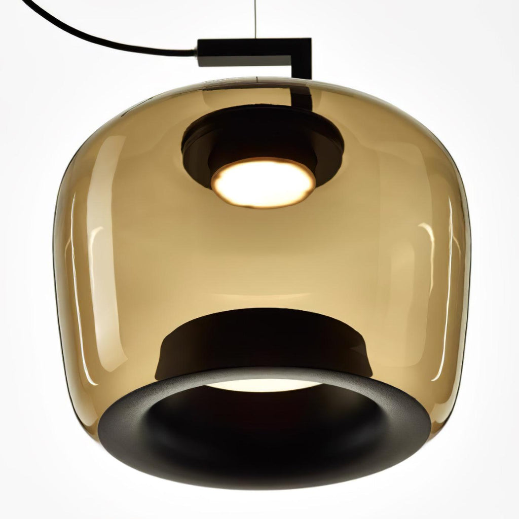 Close view from below of the amber glass shade, black inner ring and glowing light on this Clérachic pendant.
