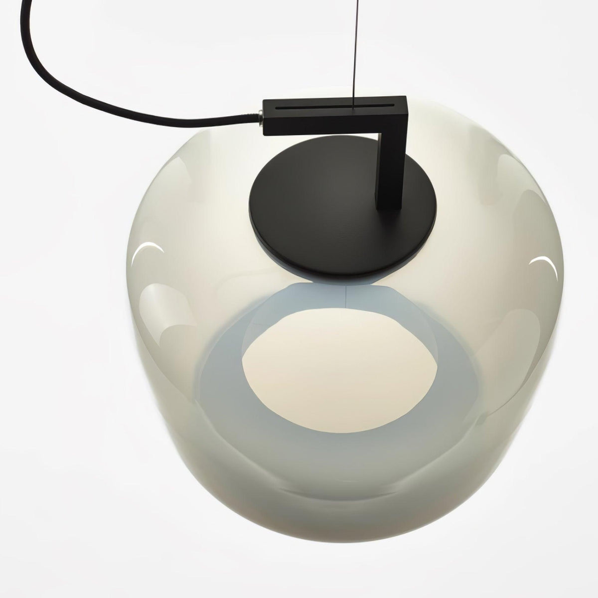 Close view from below of a foggy white glass Clérachic pendant, its black disc cap and a glowing opening visible.