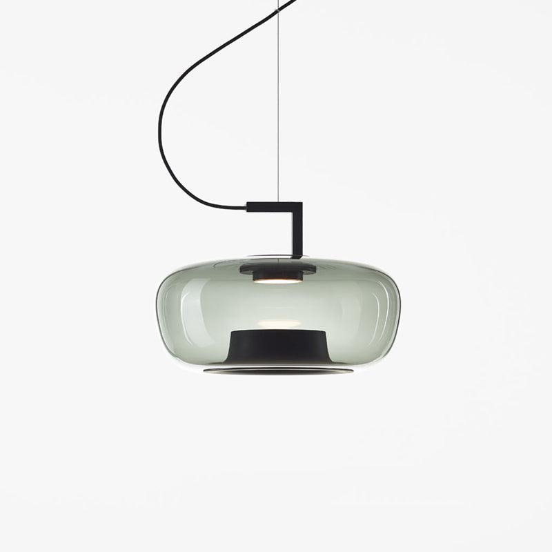 Wide grey-green glass Clérachic pendant with a black base ring and a gentle glow, on a white backdrop.