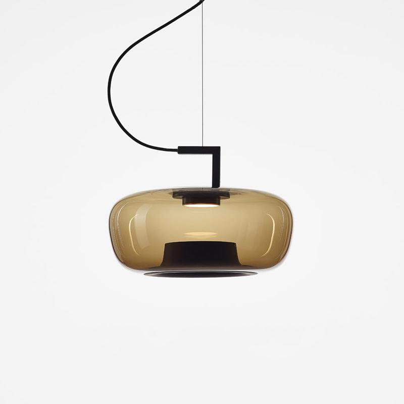 Wide amber glass Clérachic pendant with a black stem bracket and a smooth, rounded shade on a white backdrop.