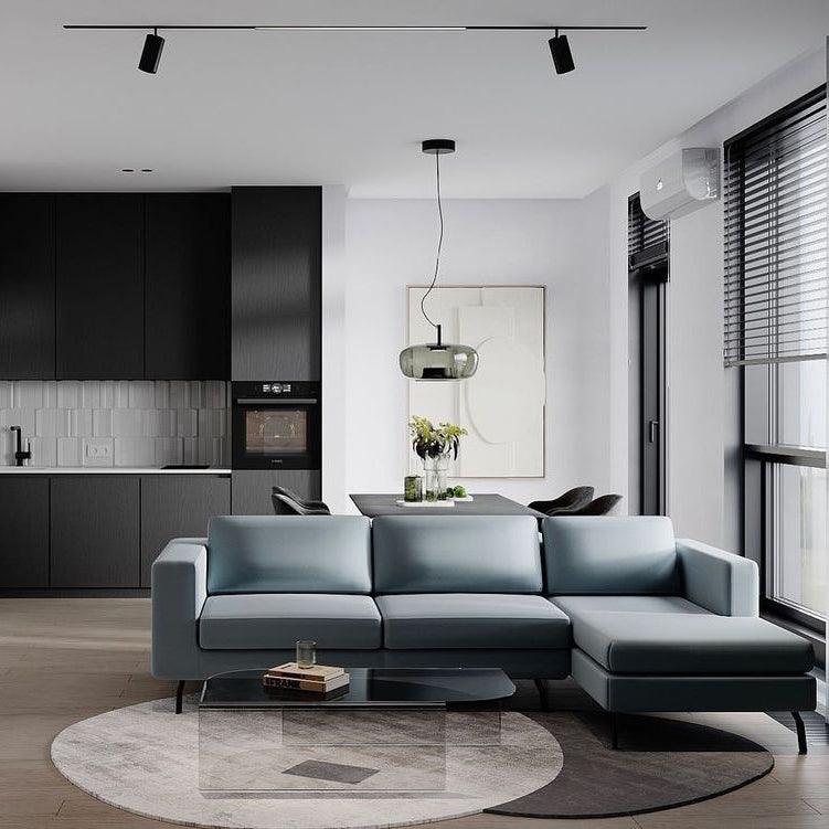 Wide smoke grey Clérachic pendant hangs over a dining table in an open-plan room with a blue-grey corner sofa.
