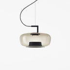 Wide foggy white glass Clérachic pendant with a soft glow and a black base ring, on a white backdrop.