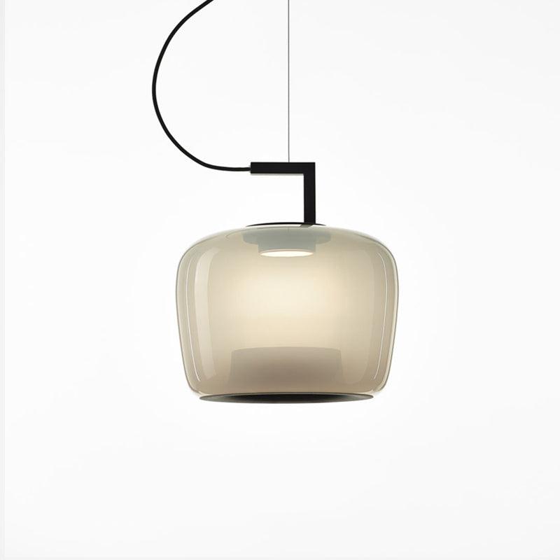 Squat foggy white glass Clérachic pendant glowing softly, with a black bracket and a thin cord, on white.