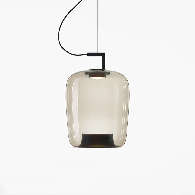 Tall foggy white glass Clérachic pendant with a black base visible through the lit glass, on a white backdrop.