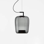 Tall smoke grey glass Clérachic pendant with a black bracket and a darker base, on a light grey backdrop.