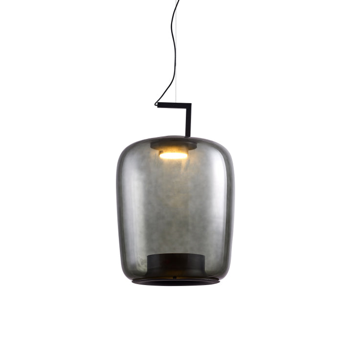 Tall smoke grey glass Clérachic pendant with a warm light glowing at its top, on a white backdrop.