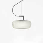Wide foggy white glass Clérachic pendant with a soft diffused glow and a black bracket, on a white backdrop.