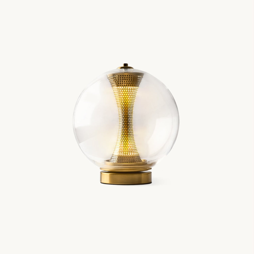 This Clérachic glass sphere table lamp on a plain white backdrop, a glowing woven brass column inside, on a gold base.