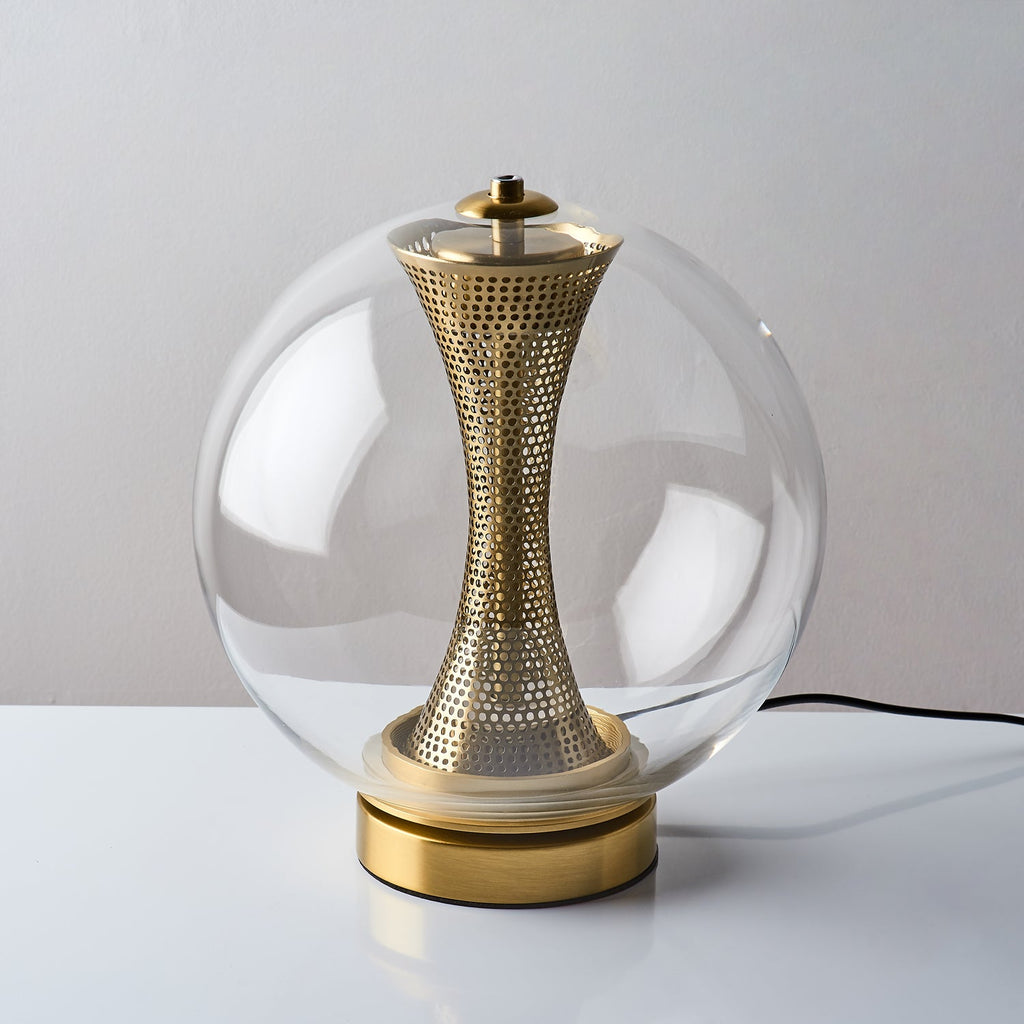 Slightly raised view of this unlit Clérachic clear-glass lamp, with its black cord and the brass column inside the sphere.