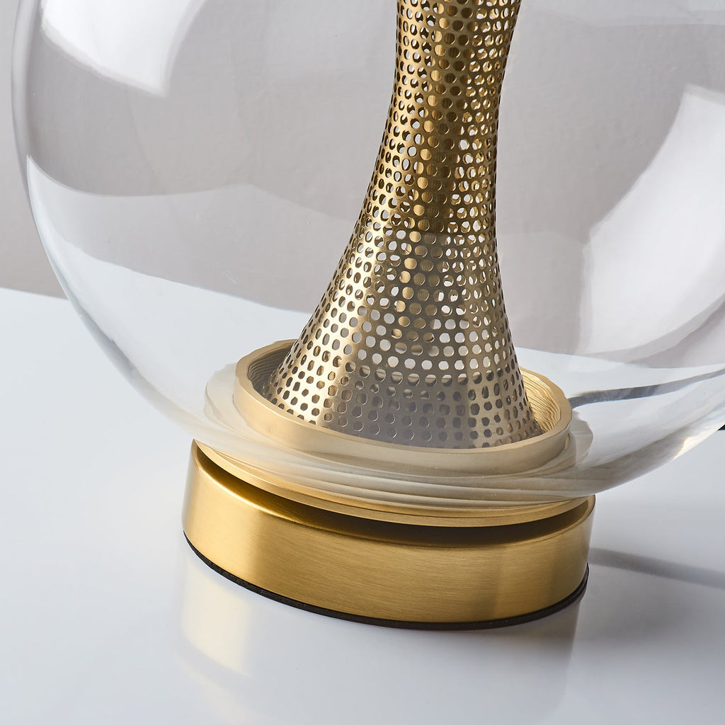 Close view of the brushed gold base and the lower end of the perforated brass column in this Clérachic sphere lamp.