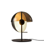 Black-based Clérachic table lamp shown straight on against white, its amber dome above a white half-sphere on a black stem.