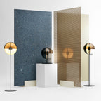 Floor and table lamps from Clérachic in the same range stand before panels of blue speckled stone and ribbed timber on a white floor.
