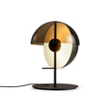 Black Clérachic table lamp with a smoked half-dome shade and a pale half-sphere, seen at a slight angle on white.