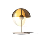White-based Clérachic table lamp with a smoked-amber dome and glowing half-sphere, photographed on a plain white ground.