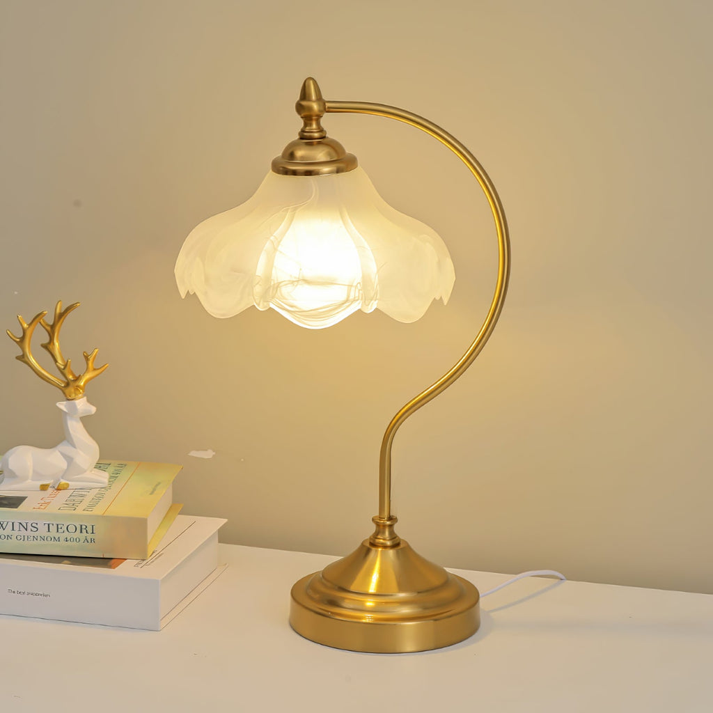 This Clérachic lamp lit warm on a white shelf, with a white deer figure and a stack of books against a golden wall.