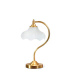 Front view of this Clérachic lamp on white, showing the white shade, the curved reeded arm and the stepped gold base.