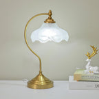 This Clérachic lamp lit on a white shelf against a soft sage wall, with a white deer figure and a stack of books to the right.