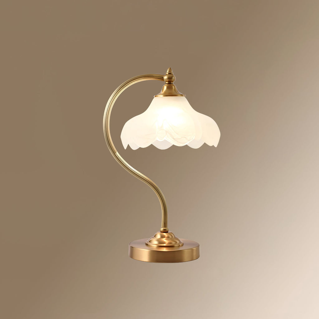 A Clérachic lamp on a warm taupe gradient backdrop, the frosted scalloped shade glowing above a gold arm and a round base.