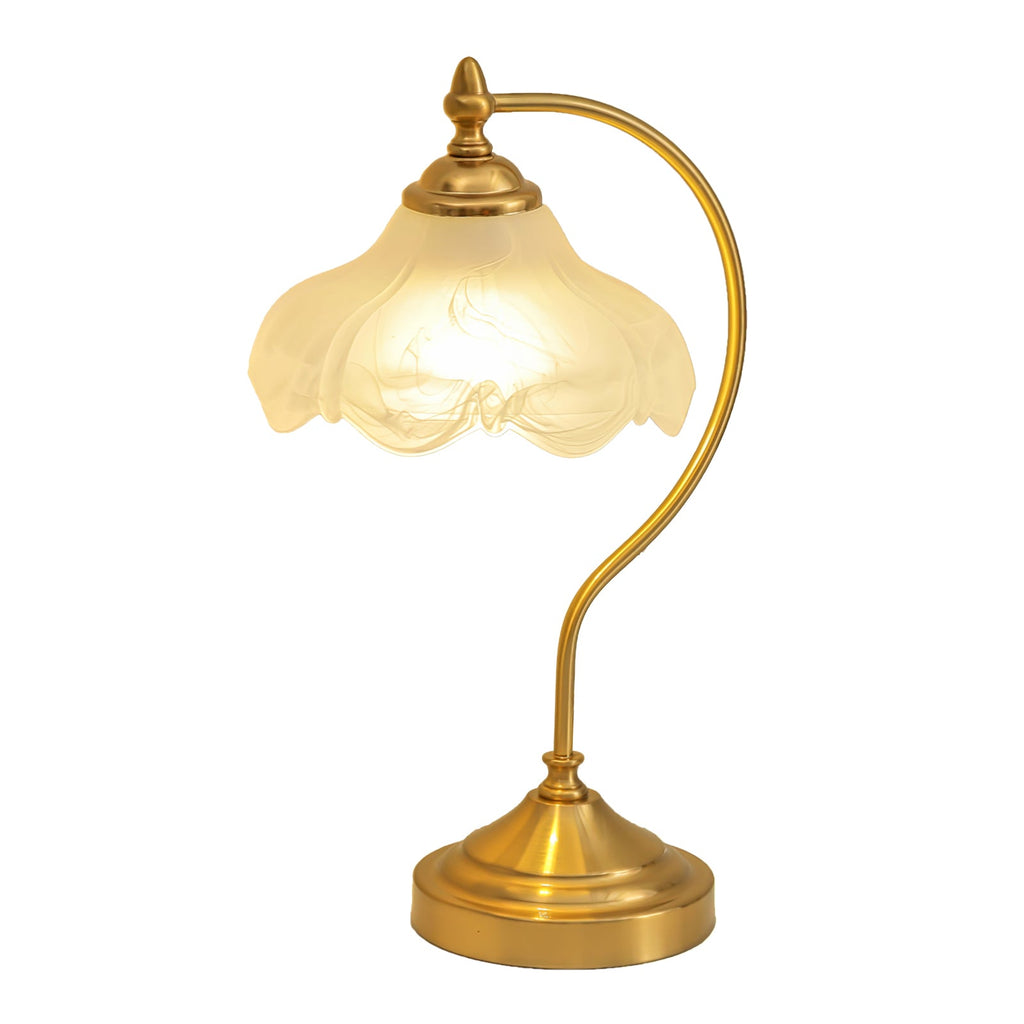 A lit Clérachic lamp on white, the amber-tinged glass glowing above a curved brass arm and a stepped round base.
