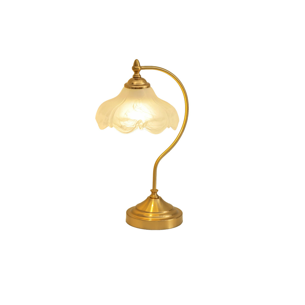 A smaller view of this Clérachic lamp lit on a white backdrop, the warm glass shade above a tall curved brass arm.