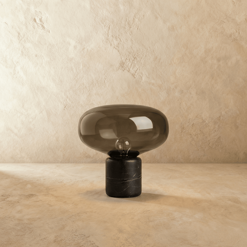Clérachic table lamp, unlit, with a rounded smoked bronze glass shade on a black veined marble column base